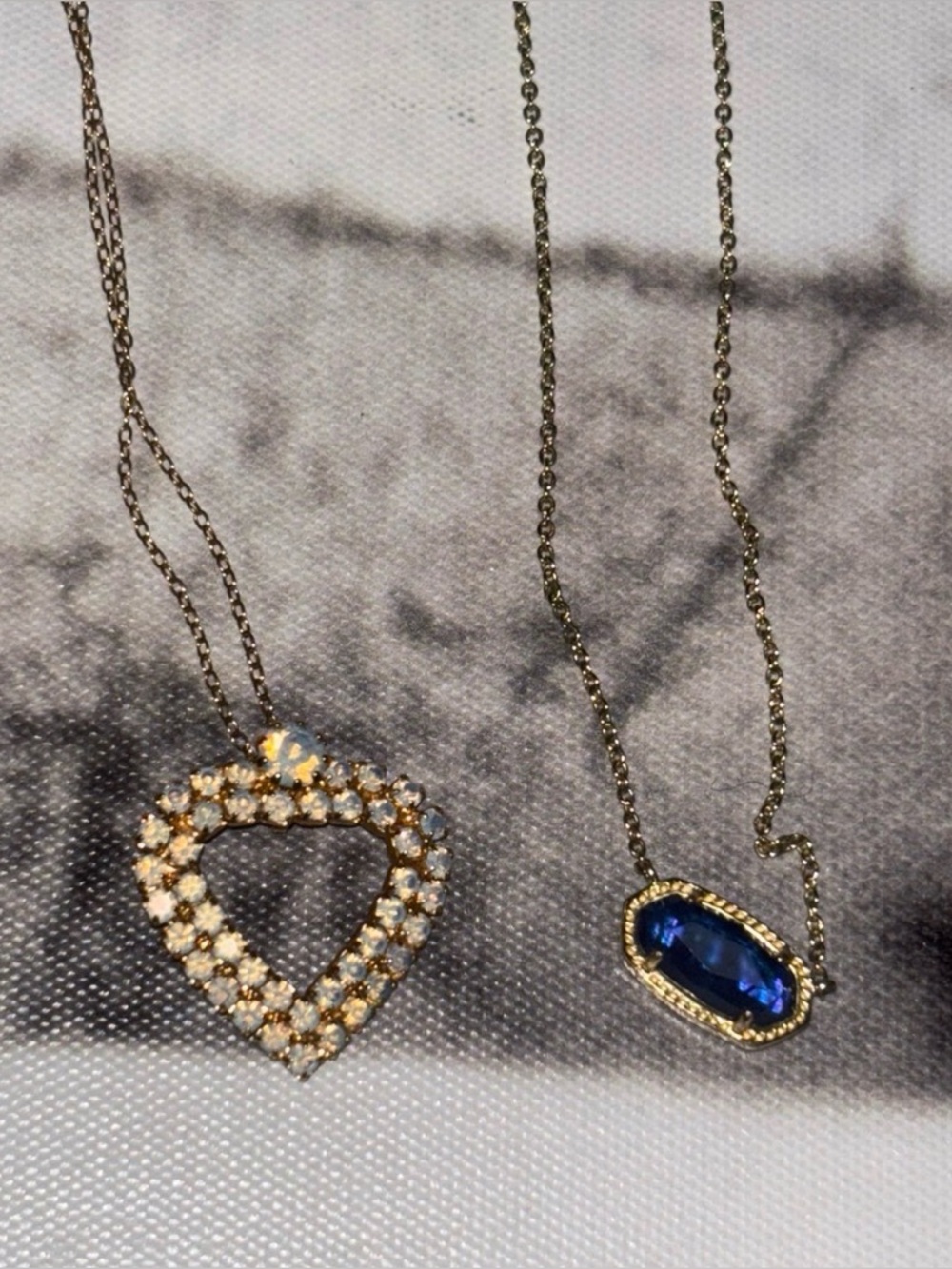 2 Gold-Tone necklaces. One Kendra Scott Tanzanite. Other Opalite heart